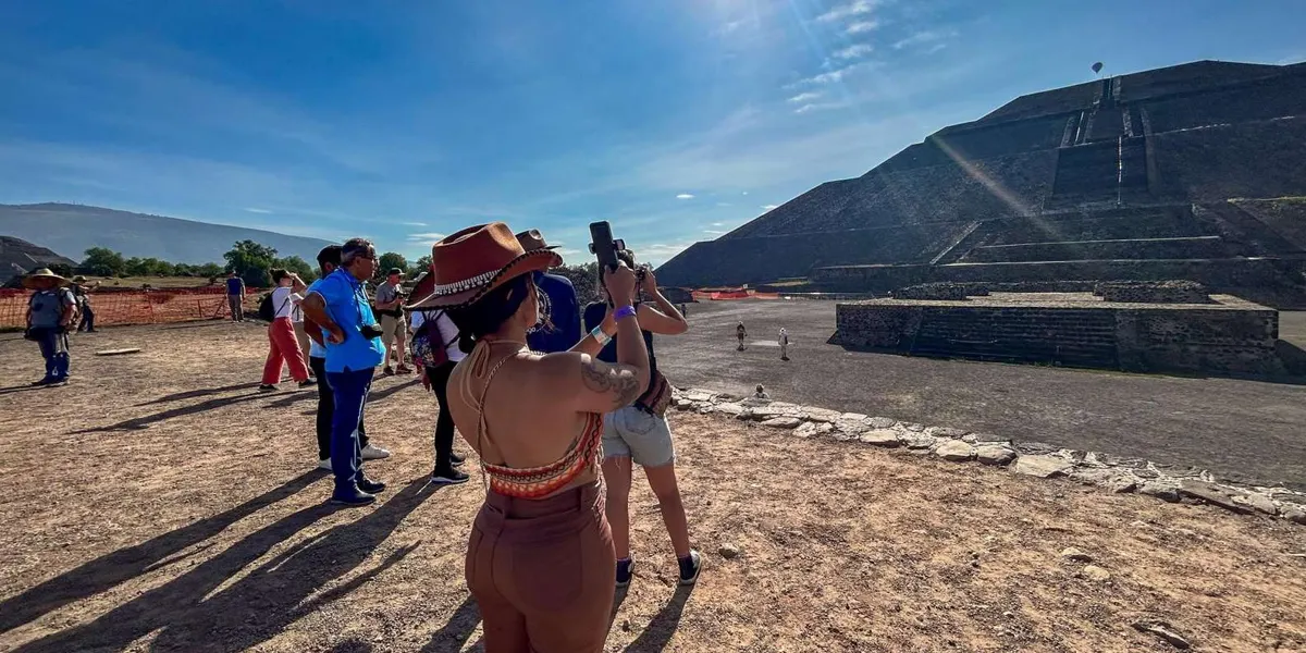 Visitors taking photographs beside a pyramid
