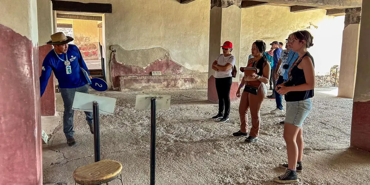 Guide showing visitors a preserved wall painting