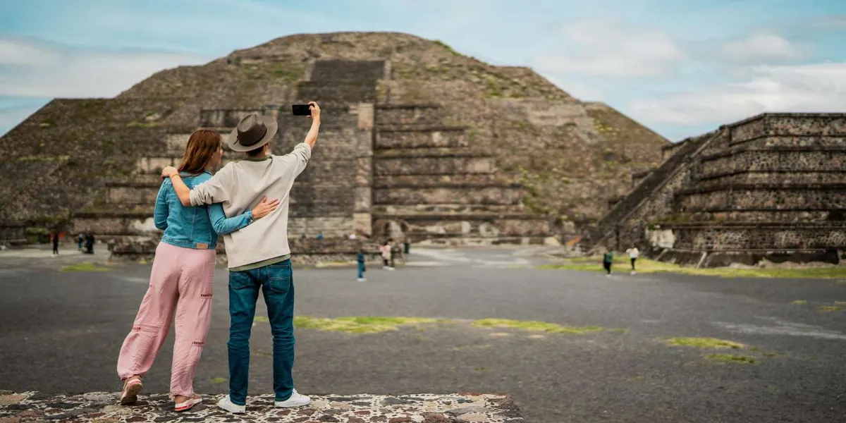 Visitors photographing a stepped pyramid