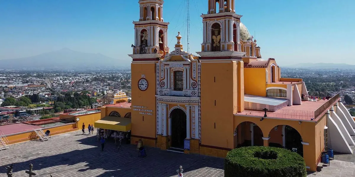Yellow church facade above Cholula with the city behind