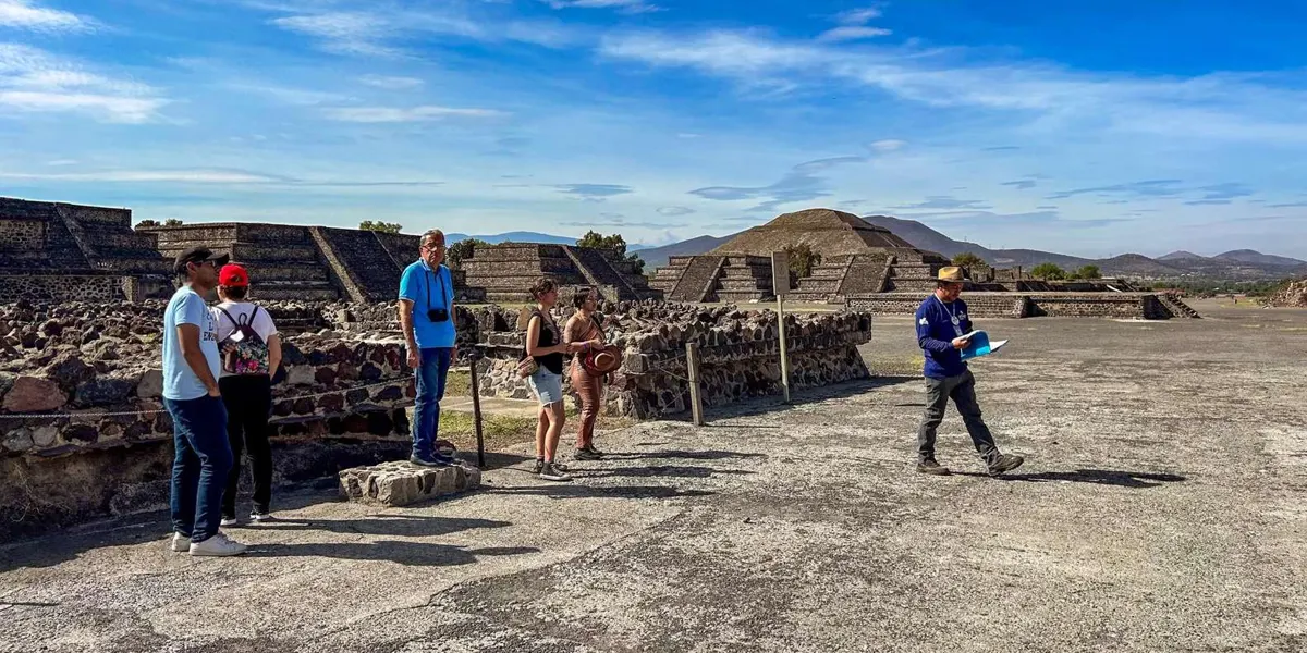 Group following a guide along Teotihuacan stone foundations