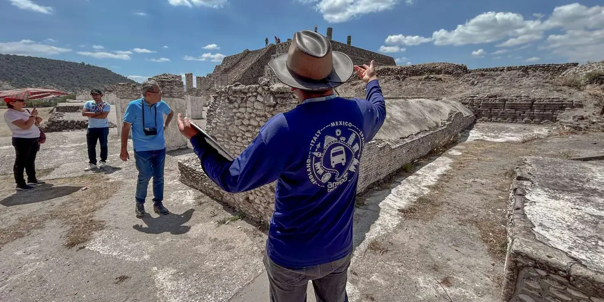 Guide explaining stone architecture to visitors