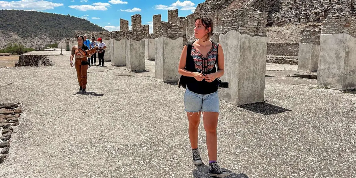 Visitor walking among columns at Tula