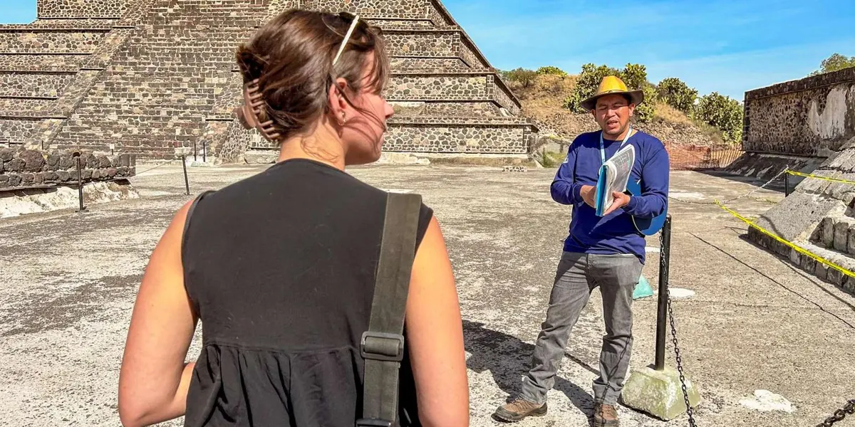 Guide and visitor discussing a stepped pyramid