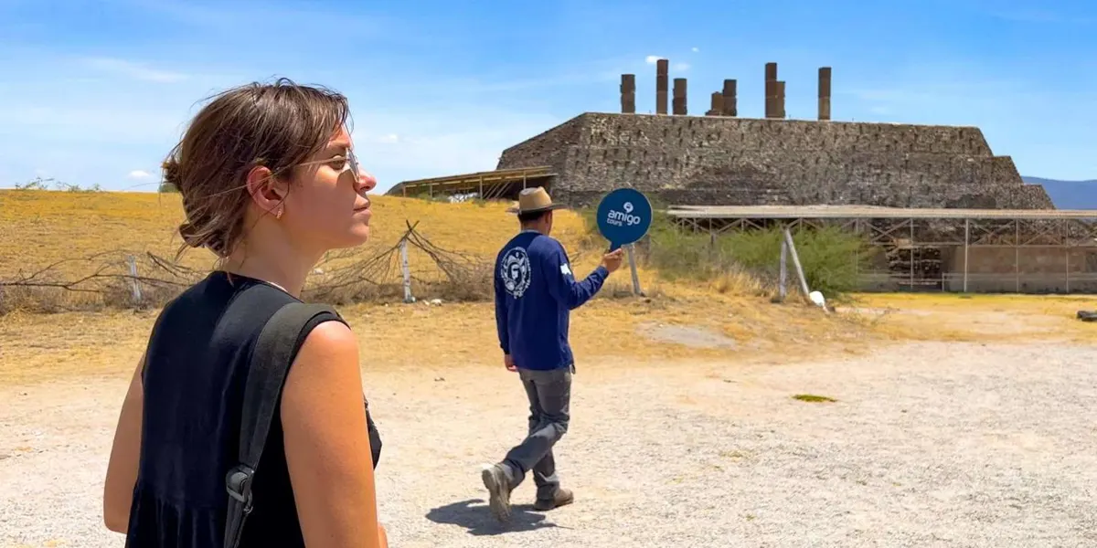 Guide pointing toward the warrior figures at Tula