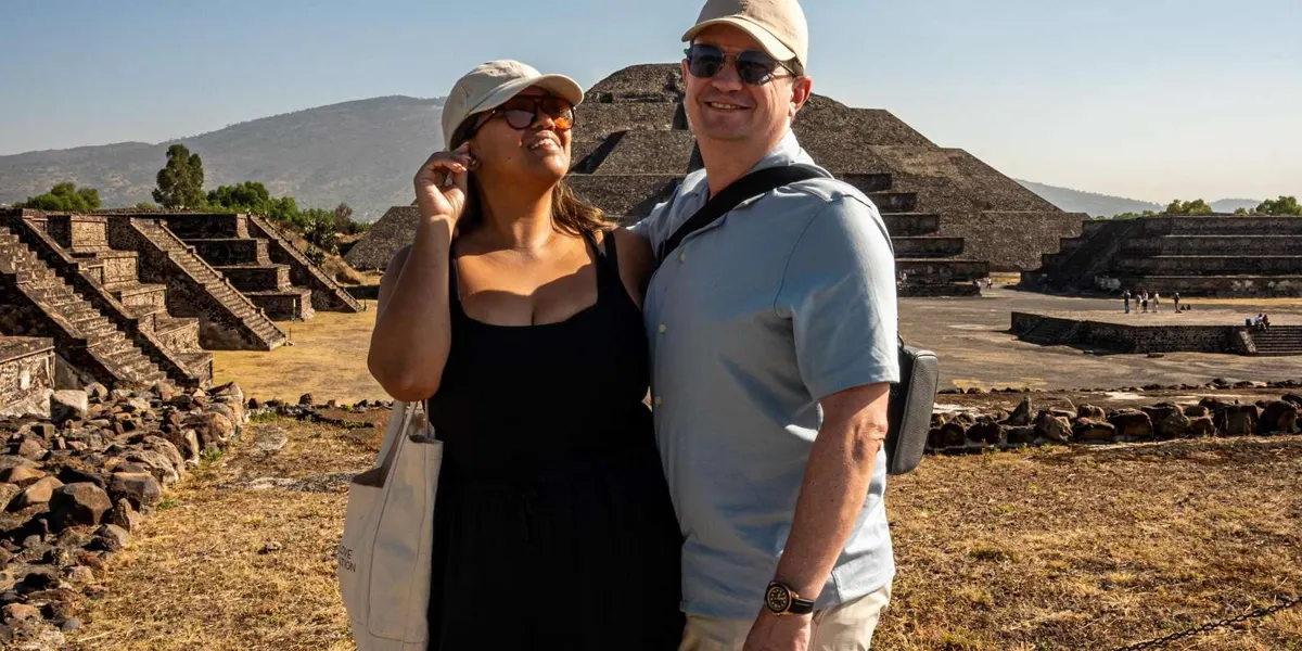 Two visitors standing in front of a Teotihuacan pyramid