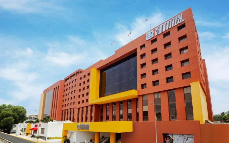 Red exterior of Camino Real Aeropuerto hotel